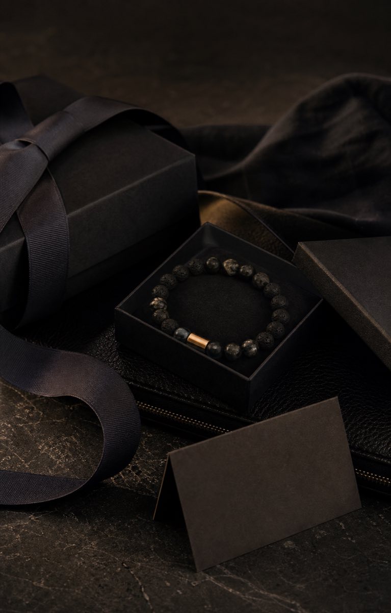 Hochwertiges dunkles Geschenk Stillleben mit Schmuck und Stoff als Symbolbild fuer Maennergeschenke