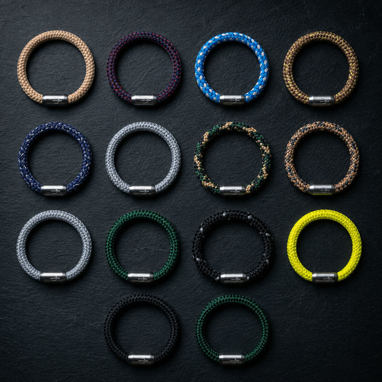 Übersicht mehrerer geflochtener Seilarmbänder in verschiedenen Farben mit Edelstahlverschluss auf dunklem Hintergrund