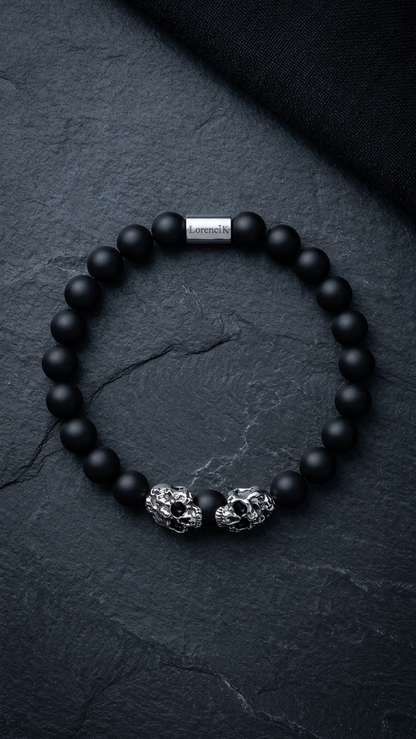 Lorencik Onyx Skull Luxe Armband mit zwei silbernen Skull-Elementen auf dunklem Schiefer