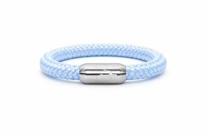 “Zartes, maritimes Armband aus hellblauem, geflochtenem Segeltau mit einem Edelstahl-Magnetverschluss, verziert mit einem eingravierten Dreizack-Symbol. Minimalistisches und stilvolles Design für einen eleganten Look.”
