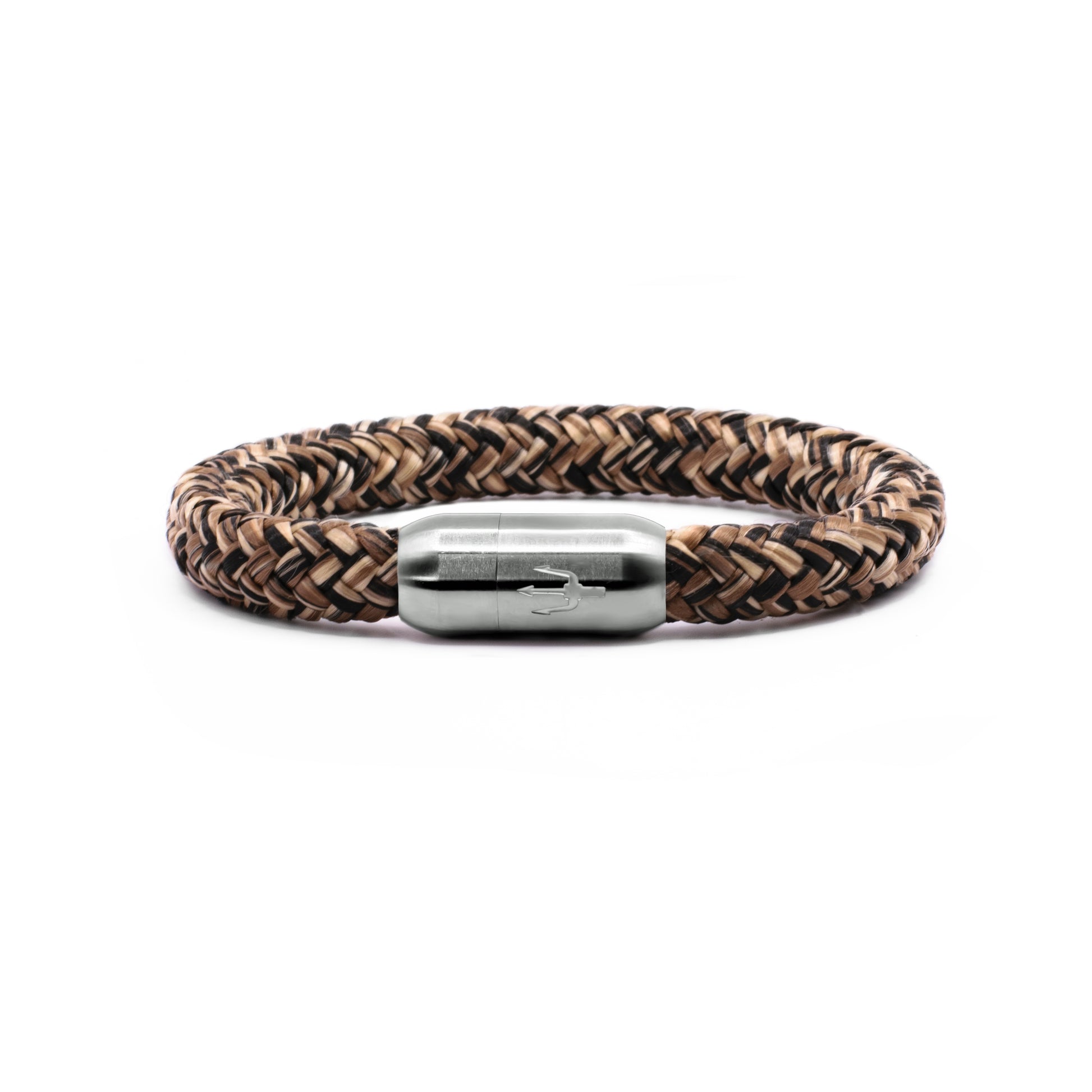 “Geflochtenes Armband in erdigen Braun- und Beigetönen mit einem Edelstahl-Magnetverschluss, verziert durch ein eingraviertes Dreizack-Symbol. Elegantes und robustes Design, inspiriert von der Kraft der Wüste.”