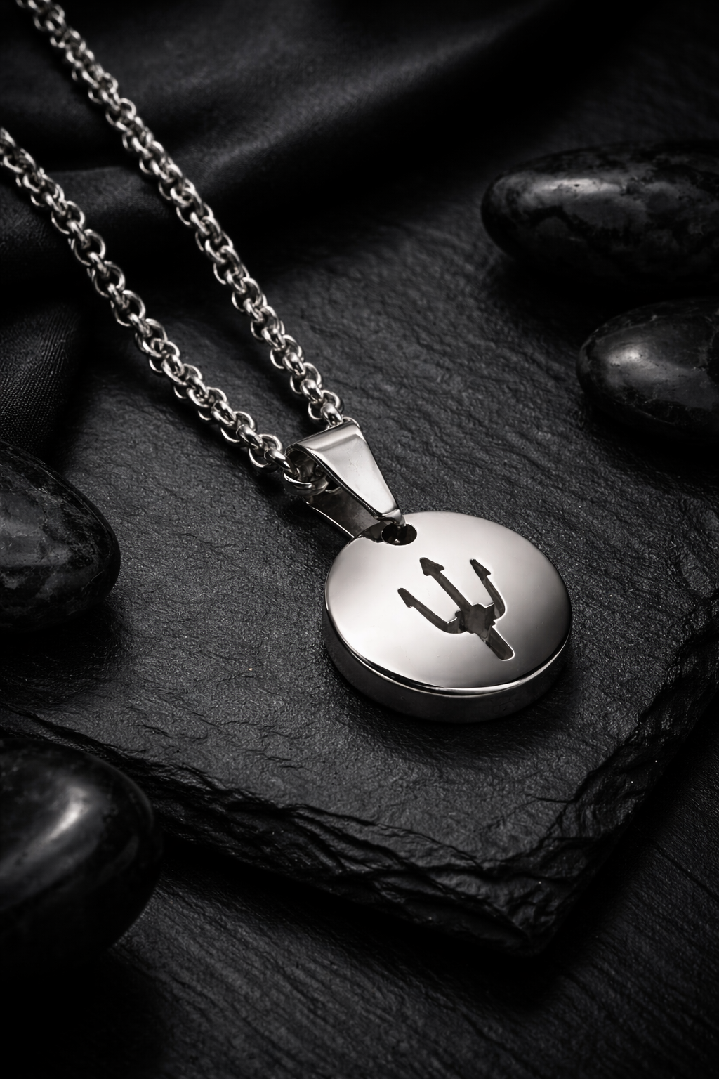 Trident Coin Edelstahl-Anhänger 304L (15 mm) mit Kette auf schwarzem Stein – luxuriöse Still-Life-Fotografie