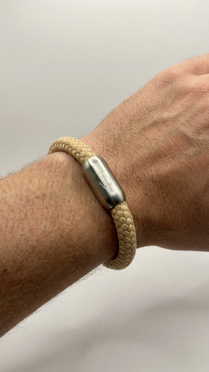 Beiges geflochtenes Seilarmband mit Edelstahlverschluss als Detailaufnahme am Handgelenk