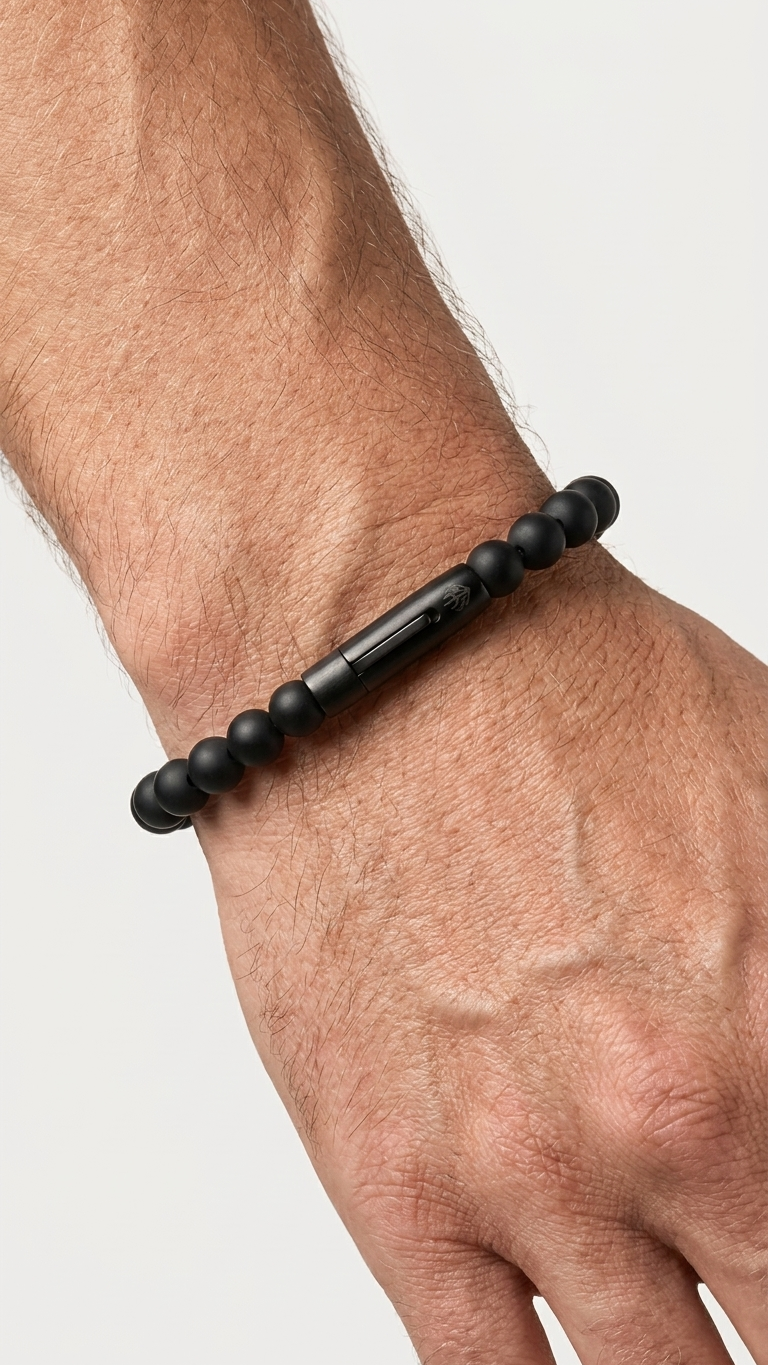 UMBRA mit schwarzen 8-mm-Onyxperlen am Handgelenk vor hellem Hintergrund
