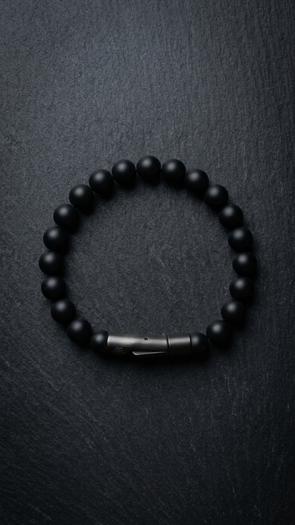 UMBRA mit matten schwarzen 8-mm-Onyxperlen und Gunmetal-Röhrenverschluss auf dunklem Schiefer