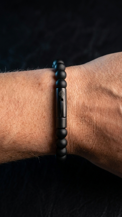 UMBRA Gunmetal-Röhrenverschluss mit dezenter Dreizack-Gravur am Handgelenk