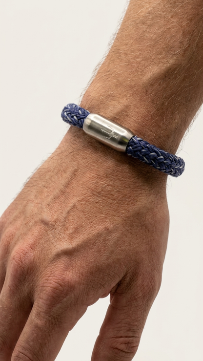 Blaues geflochtenes Seilarmband mit Edelstahlverschluss als Detailaufnahme am Handgelenk