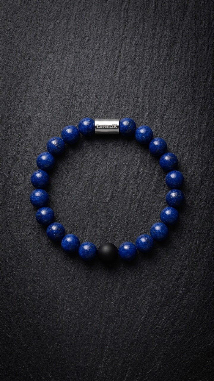 Blaues Perlenarmband mit Edelstahlverschluss und schwarzer Akzentperle auf dunklem Schiefer