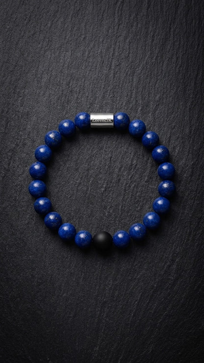 Blaues Perlenarmband mit Edelstahlverschluss und schwarzer Akzentperle auf dunklem Schiefer