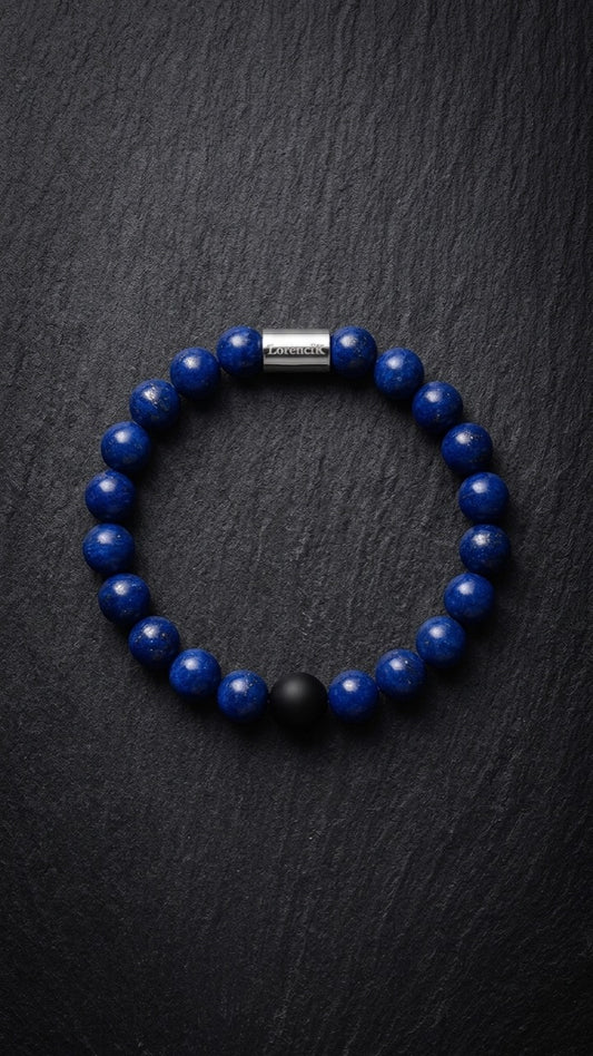 Blaues Perlenarmband mit Edelstahlverschluss und schwarzer Akzentperle auf dunklem Schiefer