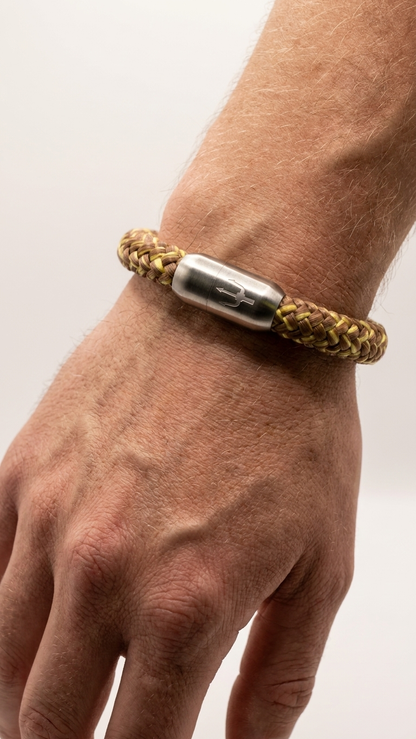 Braun-oliv-goldenes geflochtenes Seilarmband mit Edelstahlverschluss als Detailaufnahme am Handgelenk