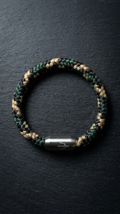 Nautic Force Woodland Camo – Segeltauarmband in Grün, Schwarz und Beige mit Edelstahl-Dreizackverschluss auf dunklem Schiefer