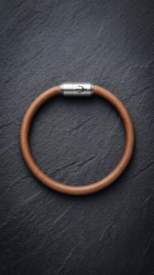 Cognacfarbenes Lederarmband mit Edelstahlverschluss auf dunklem Schiefer