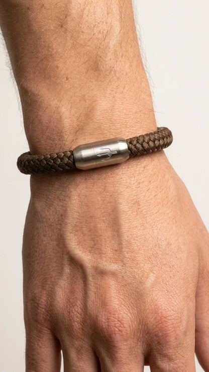 Dunkelbraunes Nautic Force Dark Harbor Segeltauarmband am Herrenhandgelenk mit Edelstahl-Magnetverschluss und Dreizack-Gravur