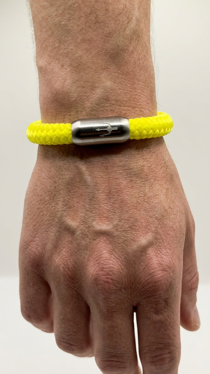 Neongelbes geflochtenes Seilarmband mit Edelstahlverschluss als Detailaufnahme am Handgelenk