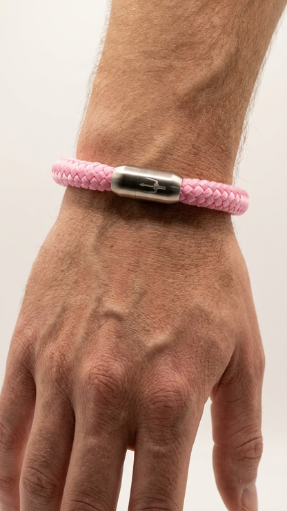 Rosa geflochtenes Seilarmband mit Edelstahlverschluss als Detailaufnahme am Handgelenk