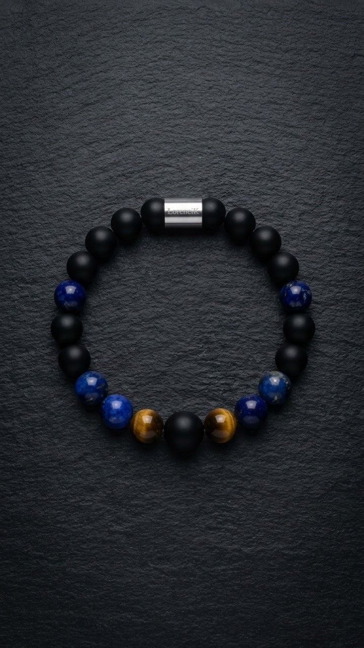 Schwarz-blaues Perlenarmband mit Tigerauge-Akzenten und Edelstahlverschluss auf dunklem Schiefer