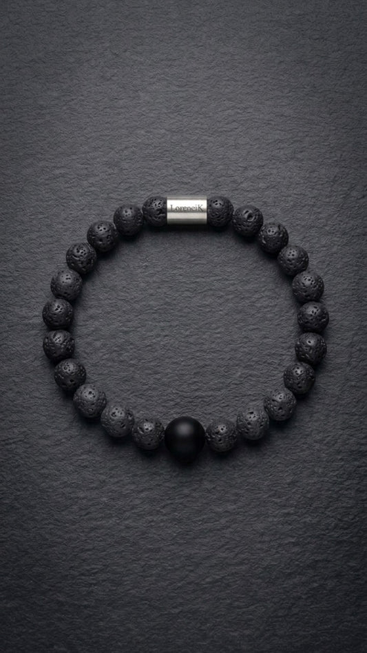 Schwarzes Lavastein-Perlenarmband mit Edelstahlverschluss auf dunklem Schiefer