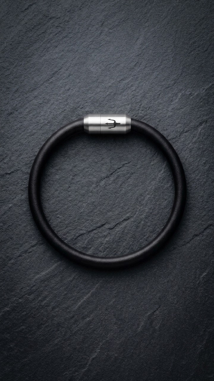 Schwarzes Lederarmband mit Edelstahlverschluss auf dunklem Schiefer