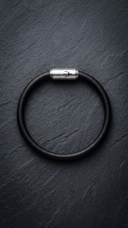 Schwarzes Lederarmband mit Edelstahlverschluss auf dunklem Schiefer