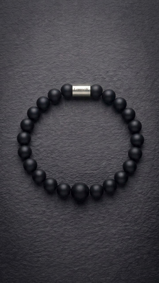 Schwarzes mattes Perlenarmband mit Edelstahlverschluss auf dunklem Schiefer