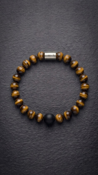 Tigerauge-Perlenarmband mit Edelstahlverschluss und schwarzer Akzentperle auf dunklem Schiefer