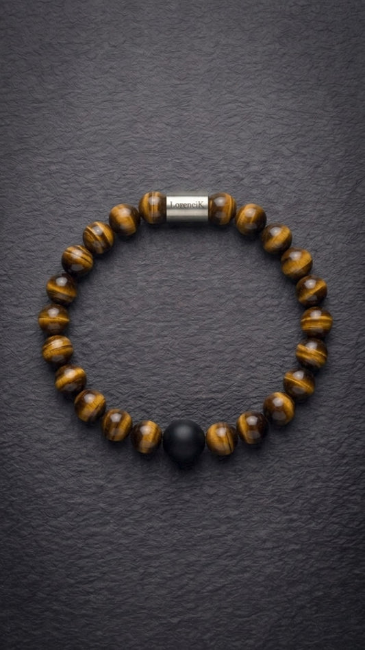 Tigerauge-Perlenarmband mit Edelstahlverschluss und schwarzer Akzentperle auf dunklem Schiefer