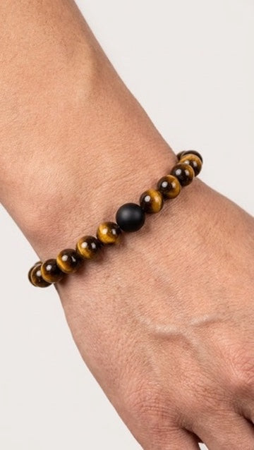 Tigerauge Perlenarmband mit schwarzer Akzentperle am Handgelenk