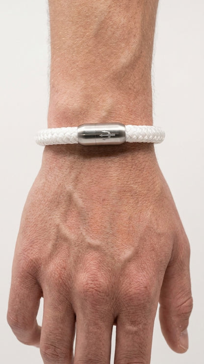 Weißes geflochtenes Seilarmband mit gebürstetem Edelstahlverschluss als Detailaufnahme am Handgelenk