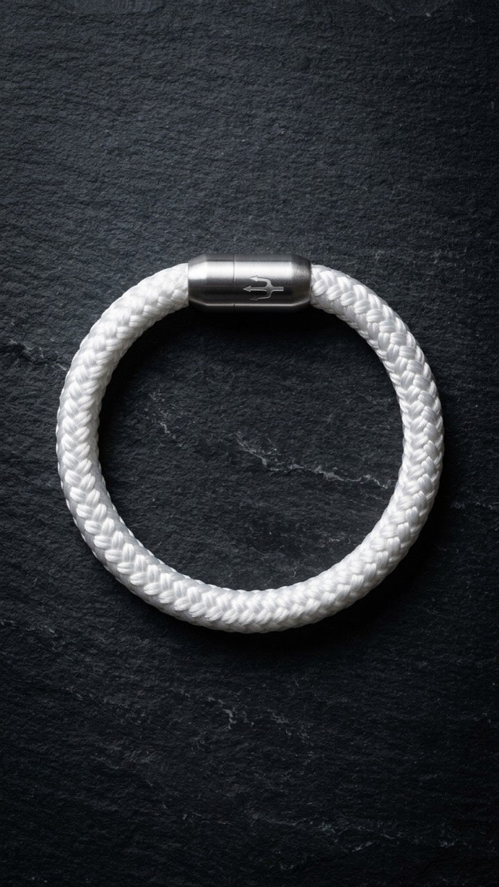 Weißes geflochtenes Seilarmband mit Edelstahlverschluss als Produktfoto auf dunklem Schiefer