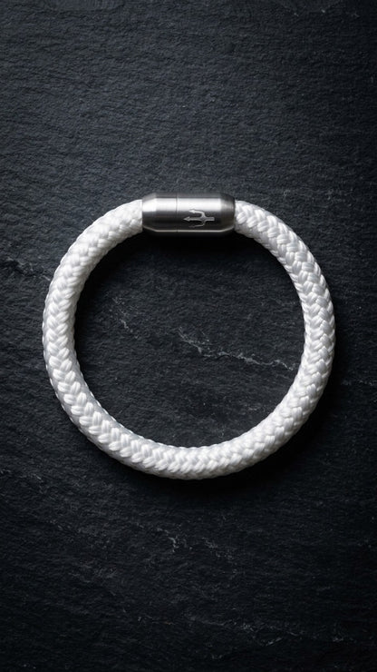 Weißes geflochtenes Seilarmband mit Edelstahlverschluss als Produktfoto auf dunklem Schiefer