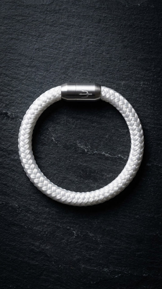 Weißes geflochtenes Seilarmband mit Edelstahlverschluss als Produktfoto auf dunklem Schiefer