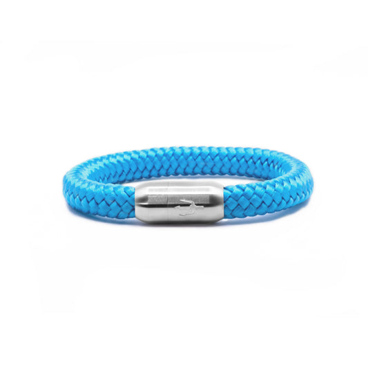 "Hellblaues Armband aus geflochtenem Segeltau mit einem Edelstahl-Magnetverschluss, verziert mit einem eingravierten Dreizack-Symbol. Frisches und modernes maritimes Design.”