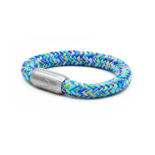 “Maritimes Armband mit geflochtenem Segeltau in lebhaften Blau-, Grün- und Lila-Tönen, ausgestattet mit einem Edelstahl-Magnetverschluss mit eingraviertem Dreizack-Symbol. Perfektes Accessoire für einen stilvollen und farbenfrohen Look.”